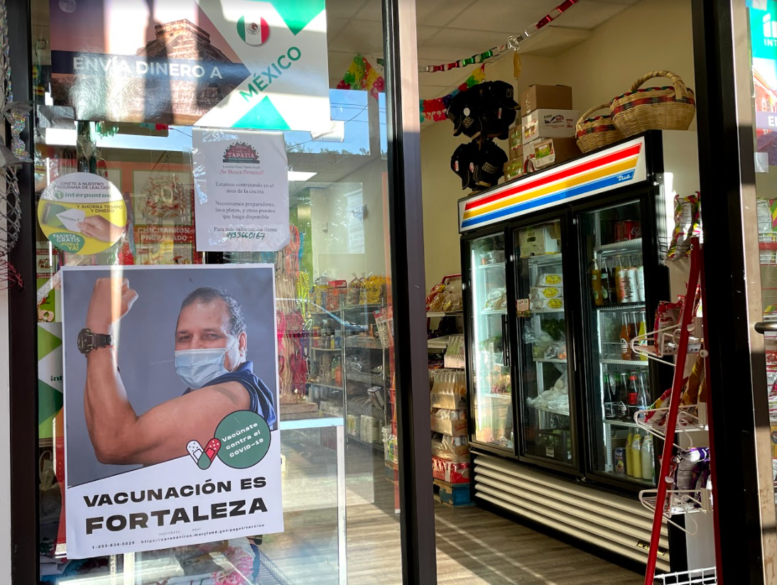 Mexican grocery store in Maryland with Vaccination Is poster hanging on the door