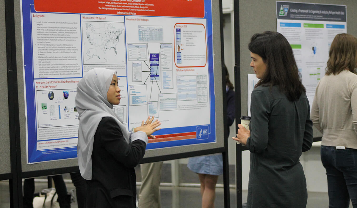 Two women standing in front of poster presentation at the 2019 NARHC conference
