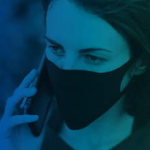 Woman in face mask takes call on call phone