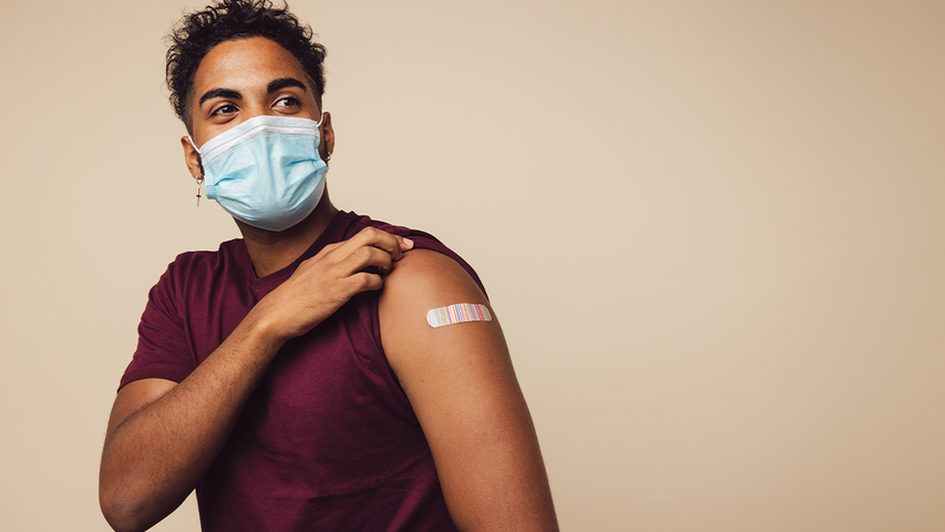 Man showing bandaid on vaccinated arm